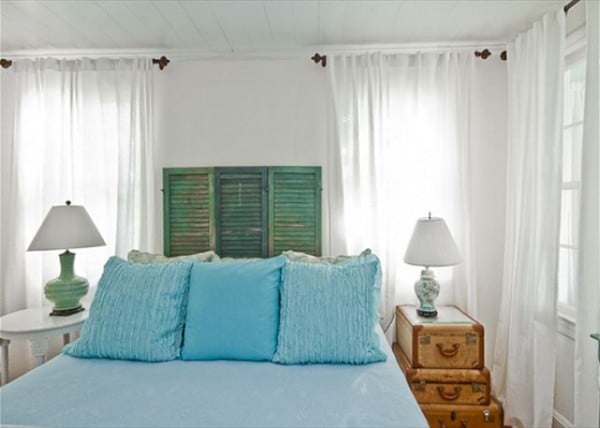 Bedroom with old shutters headboard, old trunk and suitcases table